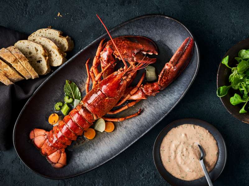 Ganzer Hummer mit Cocktailsauce und Baguette