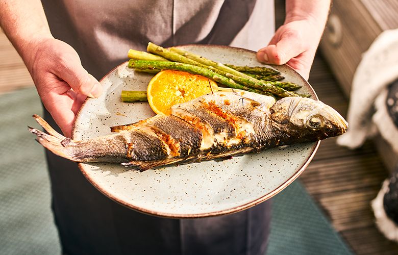 Ganze-Fische-grillen-Wolfsbarsch-auf-Teller-780x500